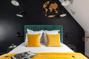 a bedroom with a large bed with yellow pillows at Hôtel - Restaurant Le Globe in Meursault