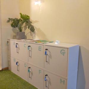 a room with four filing cabinets with a potted plant on top at TONARINO Hostel for Backpackers in Kobe