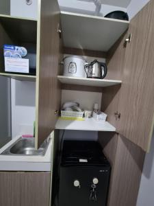 a small kitchen with a stove and a sink at Macks Awesome Place 204 NetflixFastWifi in Manila