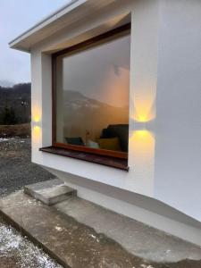 een raam aan de zijkant van een wit gebouw met verlichting bij Villa Luce in Kolašin