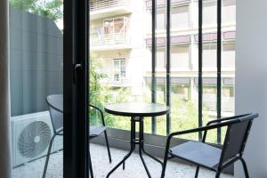 a table and chairs on a balcony with a window at Voda Luxury Residence #202 in Athens