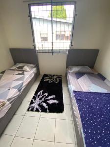 2 łóżka w pokoju z oknem i dywanem w obiekcie D’Surati River View Homestay 