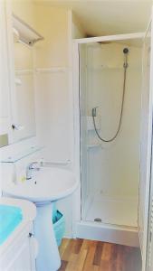a white bathroom with a shower and a sink at Seaside Tkon Mobile Homes in Tkon
