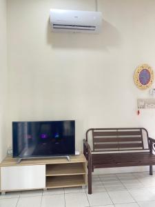 een woonkamer met een flatscreen-tv en een bank bij D’Surati River View Homestay 
