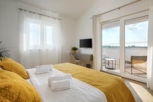 sypialnia z łóżkiem z żółtą pościelą i oknem w obiekcie Villa Rozhica w mieście Svetvinčenat