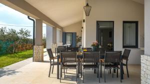 a dining room with a table and chairs on a patio at Villa Rozhica in Svetvinčenat