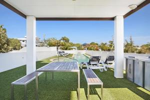 a patio with a table and chairs on a roof at Scarborough Beach Resort Brisbane in Scarborough