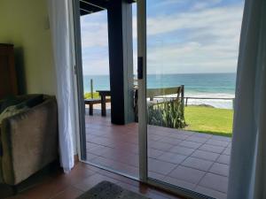 a door to a room with a view of the ocean at Mazeppa Sunrise Beach Accommodation in Mazeppa Bay