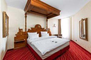 a bedroom with a large bed with a wooden canopy at KING's Hotel First in Munich