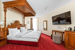 um quarto com uma cama grande e um dossel em madeira em KING's Hotel First em Munique