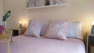 a bed with pink and white sheets and pillows at Sherryflat Trébol - Parking in Jerez de la Frontera +29 photos