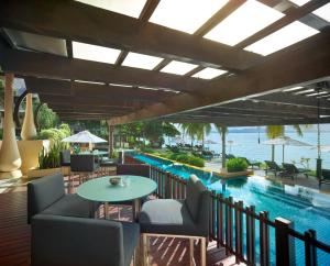 un complejo con piscina, mesas y sillas en Gaya Island Resort - Small Luxury Hotels of the World, en Isla Gaya