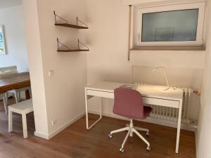 Cette chambre dispose d'un bureau, d'une chaise et d'une fenêtre. dans l'établissement Schöne Wohnung direkt am Naturpark, à Leinfelden-Echterdingen