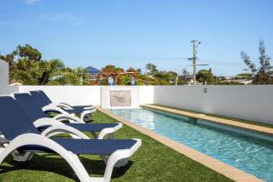 a row of chairs sitting next to a swimming pool at Scarborough Beach Resort Brisbane in Scarborough +27 photos