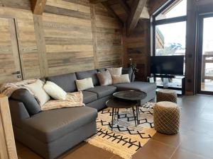 a living room with a couch and a flat screen tv at Magnifique chalet sur les pistes, le Paradis c'est là! in La Toussuire