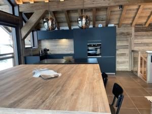 a kitchen with a large wooden table in a room at Magnifique chalet sur les pistes, le Paradis c'est là! in La Toussuire