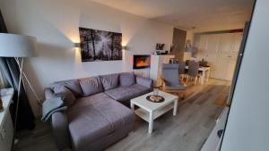 een woonkamer met een bank en een tafel bij Ferienwohnung Harzer Waldwichtel in Hahnenklee-Bockswiese