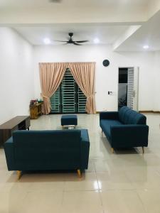 ein Wohnzimmer mit 2 Sofas und einem Tisch in der Unterkunft SUNNY HOMESTAY KUALA SELANGOR in Kuala Selangor