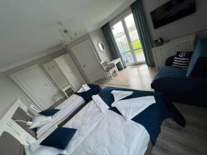 ジブヌフにあるWilla Aura Mareのベッドルーム(大型ベッド1台、青いソファ付)