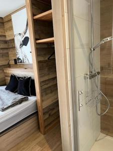 a bathroom with a shower and a bed and a glass door at Magnifique chalet sur les pistes, le Paradis c'est ici ! in La Toussuire