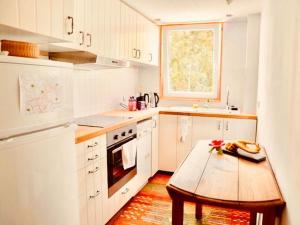 uma cozinha com armários brancos e uma mesa de madeira em Yogahaus Prasaad em Engen