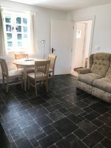 sala de estar con mesa, sillas y sofá en Kingsmills Cottages, en Artrea