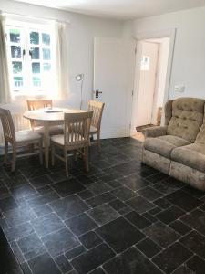 a living room with a table and chairs and a couch at Kingsmills Cottages in Artrea