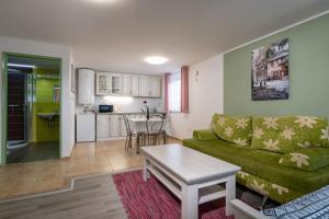Una sala de estar con un sofá verde y una mesa. en Apartmany Restart - ARESTART sk, en Liptovský Mikuláš