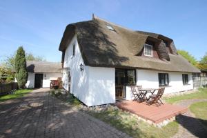 a white house with a thatched roof and a patio at Haus 1795 Stieglitz in Wustrow