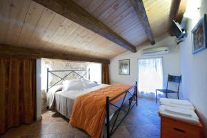 Le Case Dello Zodiaco albergo diffuso في موديكا: غرفة نوم مع سرير مع لحاف برتقالي
