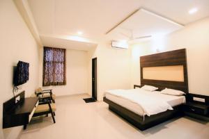 a bedroom with a large bed and a desk at Namastay welcome home - Abu Road in Ābu Road