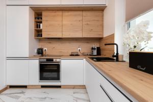 a kitchen with white cabinets and a sink at Apartments Beaufort Estate by Renters in Gdynia