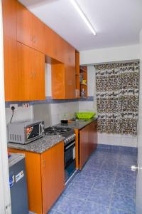 a kitchen with wooden cabinets and a stove top oven at Nairobi Airport Apartments in Syokimau