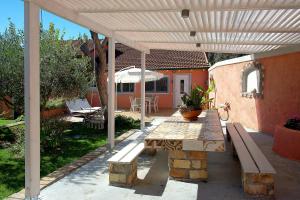 un patio con pergolato in legno e panca di Paliabelo Village House a Skriperón