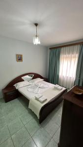 a bedroom with a large bed and a chandelier at Comfort 2 Apartment in Sarandë