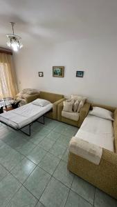 a living room with two beds and a couch at Comfort 2 Apartment in Sarandë +11 photos
