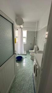 a bathroom with two toilets and two sinks and a window at Comfort 2 Apartment in Sarandë