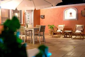 patio con tavolo, sedie e ombrellone di Paliabelo Village House a Skriperón