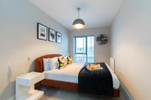 ein Schlafzimmer mit einem Bett und einem Fenster in der Unterkunft Elliot Oliver - Chic 2 Bedroom Town Centre Apartment in Cheltenham