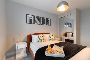 a bedroom with a bed with a tray of food on it at Elliot Oliver - Chic 2 Bedroom Town Centre Apartment in Cheltenham