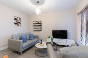 ein Wohnzimmer mit Sofa und Fernseher in der Unterkunft Elliot Oliver - Chic 2 Bedroom Town Centre Apartment in Cheltenham