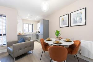 ein Wohnzimmer mit einem Tisch und einem Stuhl in der Unterkunft Elliot Oliver - Chic 2 Bedroom Town Centre Apartment in Cheltenham + 17 Fotos