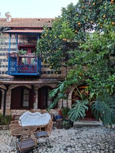una mesa y sillas frente a un edificio con un naranjo en וילה תהילה המחודש - The new Villa Tehila en Rosh Pinna