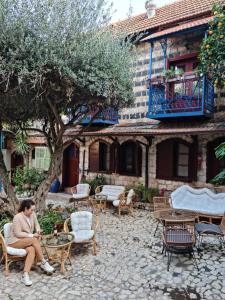 a woman sitting in a chair in front of a building at וילה תהילה המחודש - The new Villa Tehila in Rosh Pinna