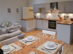 a kitchen and a living room with a table and chairs at Blyth Green Stable in Long Stratton