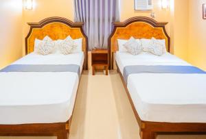 two beds in a hotel room with two beds at RedDoorz Plus @ Hotel Platinum Occidental Mindoro in San Jose
