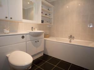 a bathroom with a toilet and a sink and a tub at Harbour View in Pevensey
