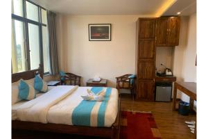 Hotel Tapas في كاتماندو: غرفة نوم مع سرير ووسائد زرقاء وبيضاء