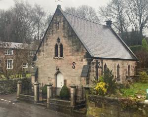 an old stone church with a cross on it at The White Hart Apartment Church View in Alton