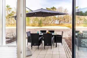 einen Tisch und Stühle mit Sonnenschirm auf einer Terrasse in der Unterkunft Ferienwohnung Sonnenschein Haus Hiddensee Prora in Binz